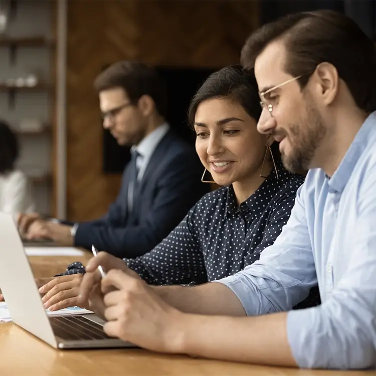 Deux personnes regardent un schéma Sage Network illustrant la synchronisation des flux ERP et un Graphique des nouveaux modèles de données et flux automatisés ERP/Sage Network