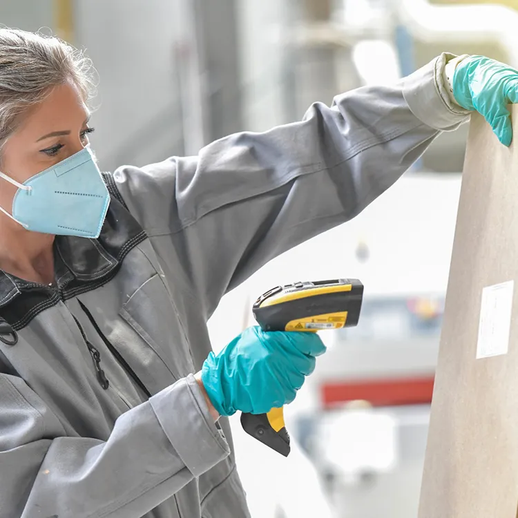 Opératrice en train de scanner une étiquette pour vérifier la traçabilité de son produit en utilisant un logiciel MES Aquiweb